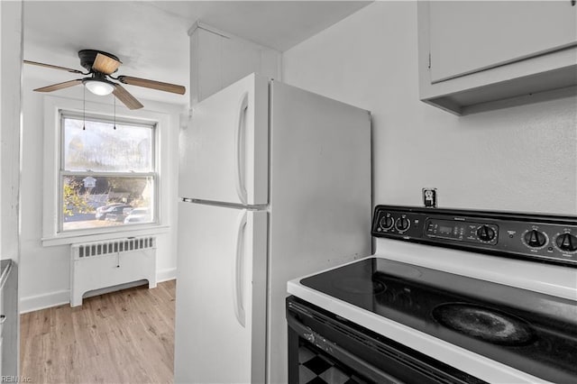 kitchen featuring radiator, white cabinetry, ceiling fan, light hardwood / wood-style floors, and white appliances