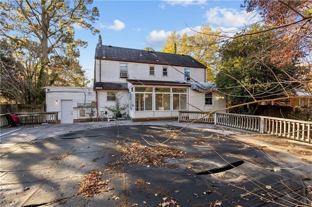 back of property featuring a sunroom and a wooden deck