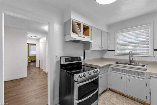 kitchen featuring backsplash, sink, stainless steel electric range, and light hardwood / wood-style flooring