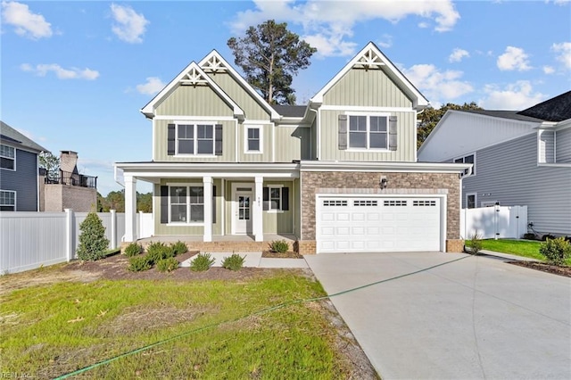 craftsman-style home with covered porch, a front yard, and a garage