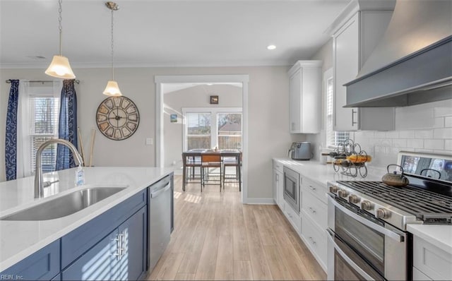 kitchen with white cabinetry, sink, stainless steel appliances, pendant lighting, and custom exhaust hood