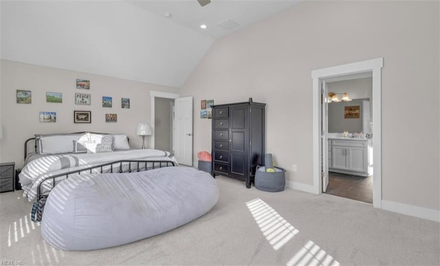 carpeted bedroom with ensuite bath, ceiling fan, and high vaulted ceiling