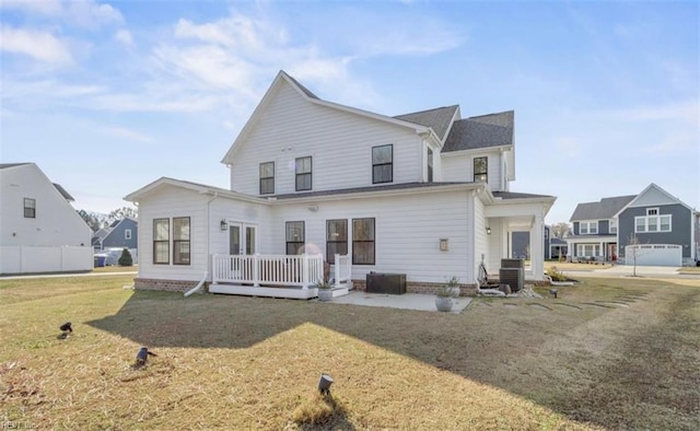 rear view of property featuring central AC, a wooden deck, and a lawn