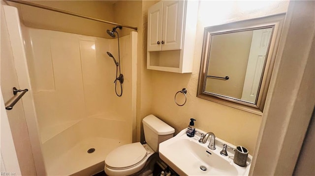 bathroom featuring toilet, sink, and walk in shower