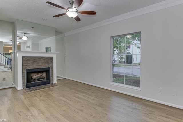 unfurnished living room with a textured ceiling, ceiling fan, light hardwood / wood-style floors, and crown molding