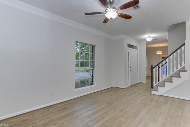 interior space featuring plenty of natural light, ornamental molding, a textured ceiling, and light hardwood / wood-style flooring