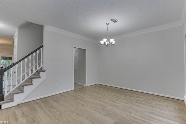 unfurnished room featuring a chandelier, ornamental molding, a textured ceiling, and light hardwood / wood-style flooring