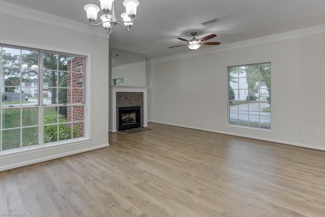 unfurnished living room featuring a fireplace, light hardwood / wood-style floors, a wealth of natural light, and ornamental molding