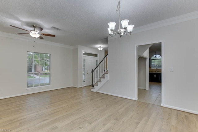 spare room with a textured ceiling, ceiling fan with notable chandelier, crown molding, and light hardwood / wood-style flooring