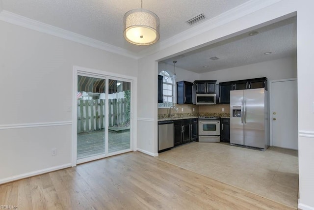 kitchen featuring ornamental molding, a textured ceiling, stainless steel appliances, sink, and light hardwood / wood-style flooring