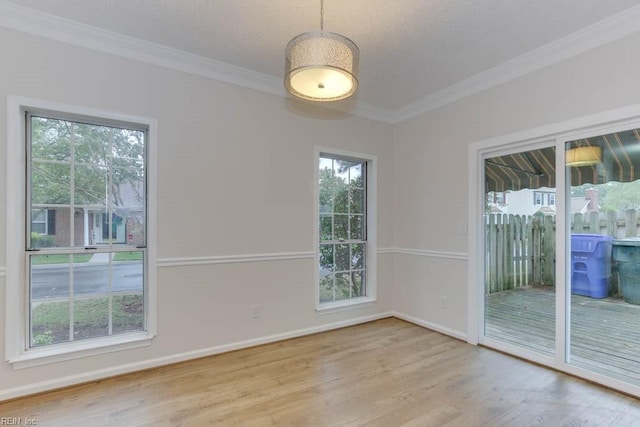 unfurnished room featuring a textured ceiling, light hardwood / wood-style flooring, and ornamental molding