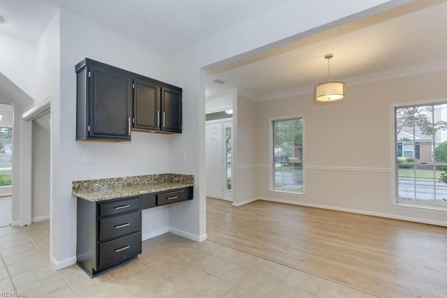 kitchen featuring ornamental molding, hanging light fixtures, a healthy amount of sunlight, and light hardwood / wood-style floors