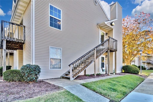 view of home's exterior with a yard and a balcony