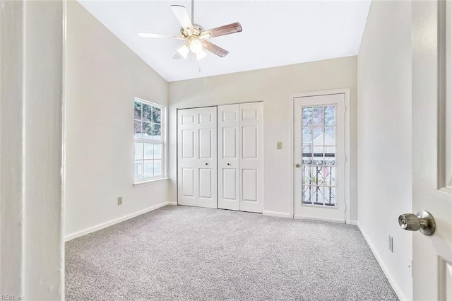 unfurnished bedroom with ceiling fan, lofted ceiling, carpet floors, and multiple windows