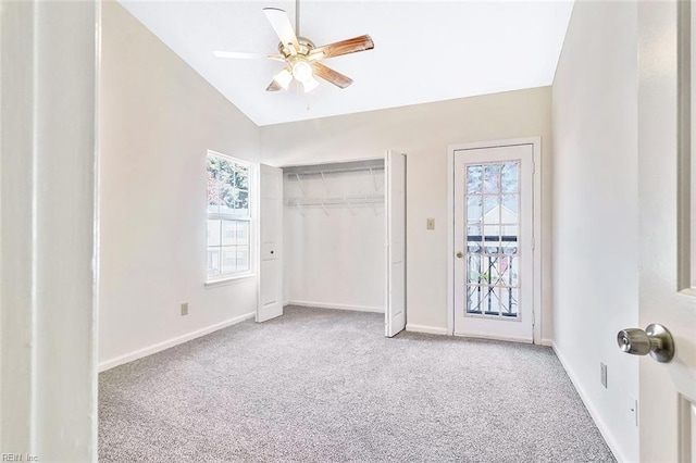 unfurnished bedroom featuring light carpet, multiple windows, lofted ceiling, and ceiling fan