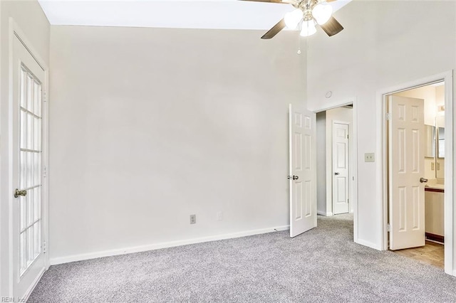 unfurnished bedroom featuring ensuite bath, light carpet, and ceiling fan