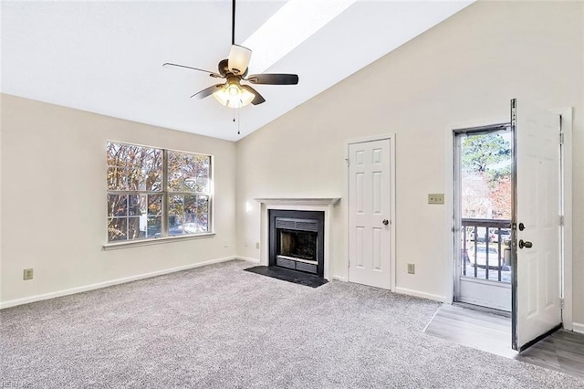 unfurnished living room with ceiling fan, light colored carpet, and high vaulted ceiling