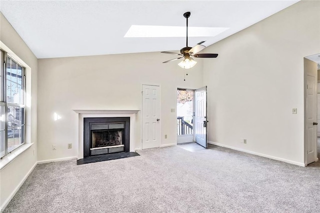 unfurnished living room with light carpet, a skylight, plenty of natural light, and ceiling fan