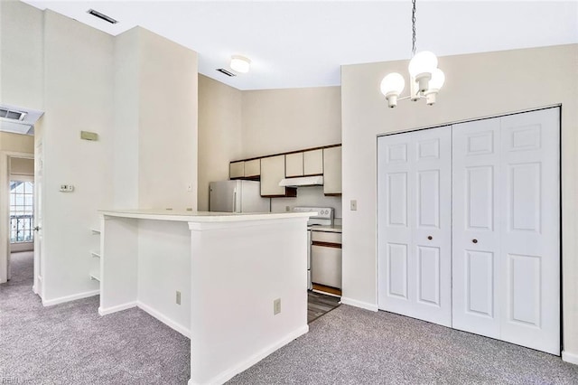 kitchen featuring kitchen peninsula, carpet flooring, decorative light fixtures, white cabinetry, and stainless steel refrigerator