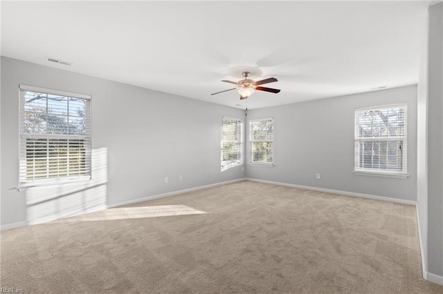 empty room featuring light colored carpet and a healthy amount of sunlight