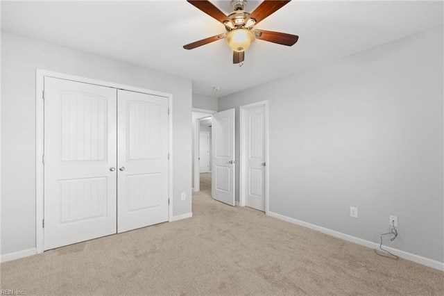 unfurnished bedroom with ceiling fan, a closet, and light colored carpet