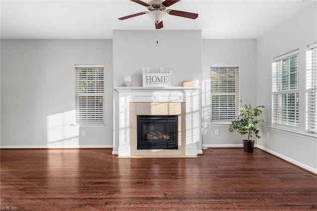 unfurnished living room with a healthy amount of sunlight, dark hardwood / wood-style flooring, and a tiled fireplace