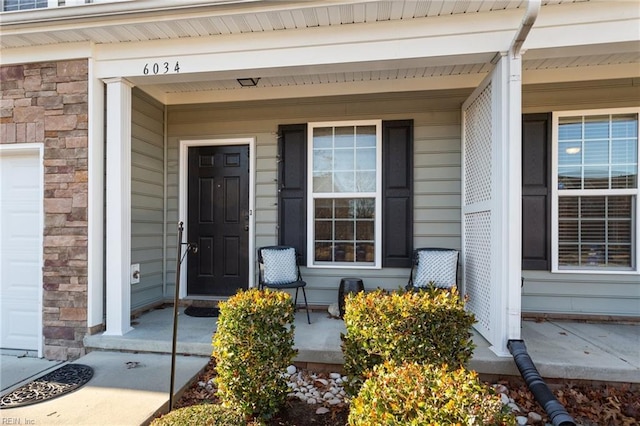 view of exterior entry featuring covered porch