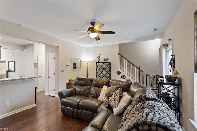 living room featuring ceiling fan and dark hardwood / wood-style flooring