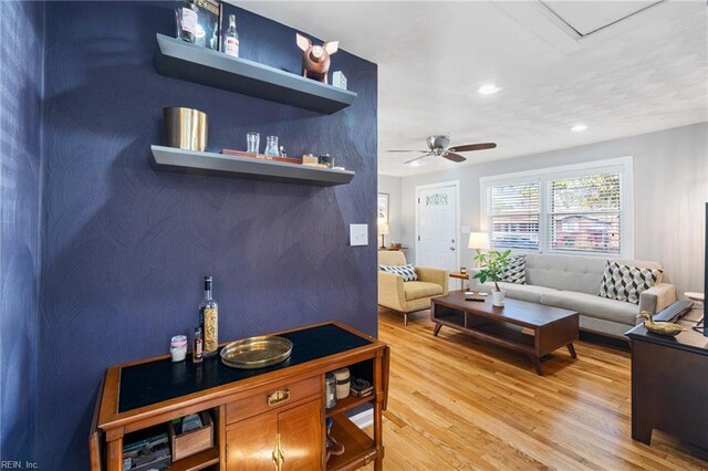 living room with wood-type flooring and ceiling fan