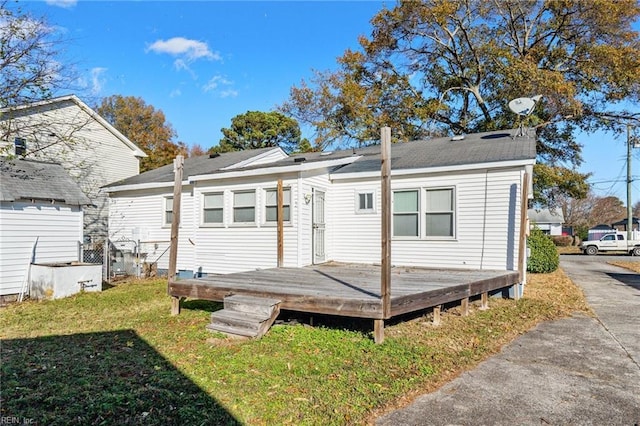 rear view of house featuring a yard and a wooden deck