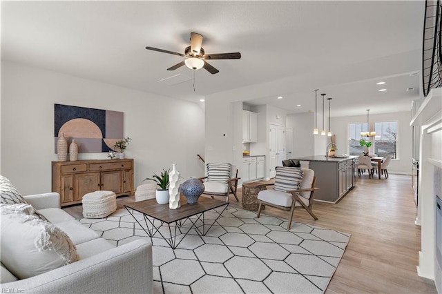 living room featuring ceiling fan, light hardwood / wood-style flooring, and sink