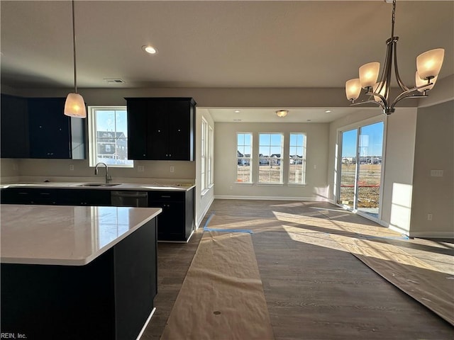 kitchen with a kitchen island, dark hardwood / wood-style floors, decorative light fixtures, black dishwasher, and sink