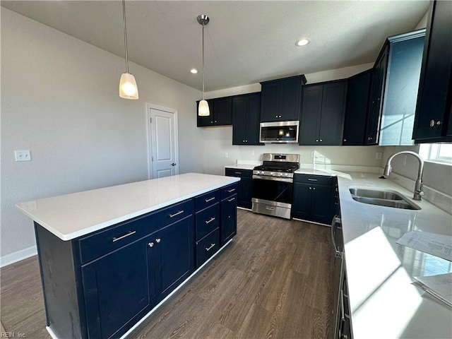 kitchen with appliances with stainless steel finishes, dark hardwood / wood-style floors, decorative light fixtures, sink, and a center island