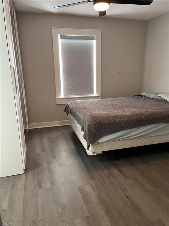 unfurnished bedroom with ceiling fan and wood-type flooring