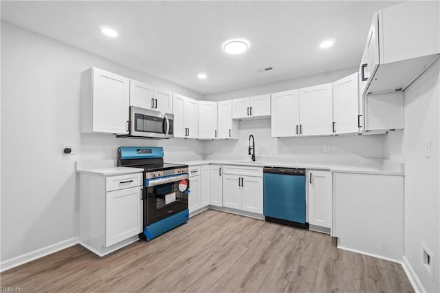 kitchen featuring light wood-type flooring, stainless steel appliances, white cabinetry, and sink