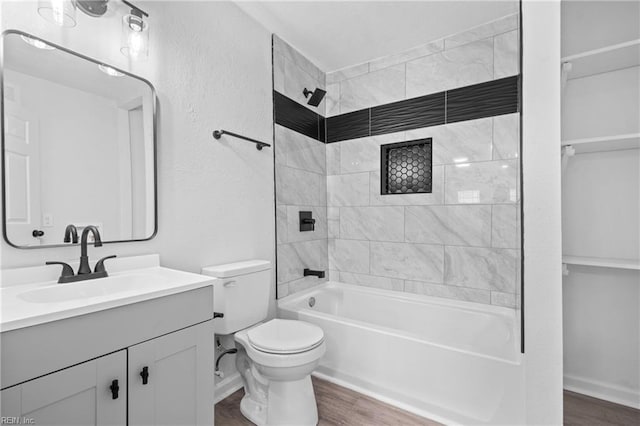 full bathroom featuring vanity, toilet, wood-type flooring, and tiled shower / bath