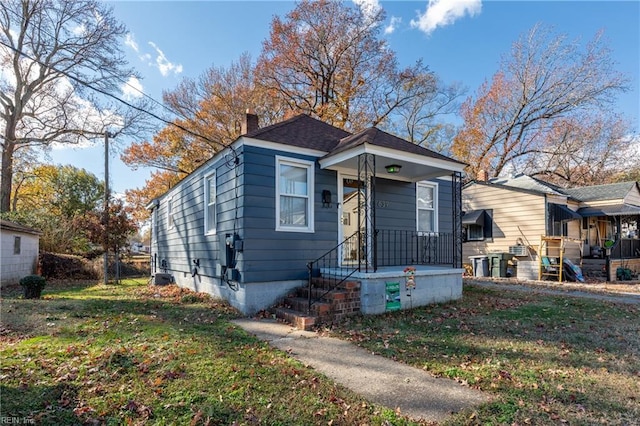 bungalow-style home with a front yard