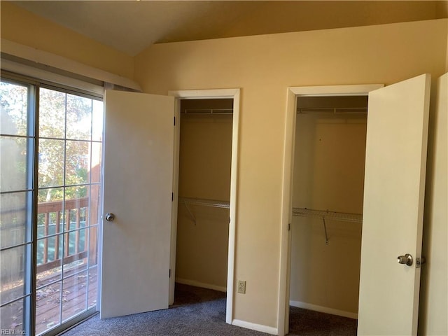 unfurnished bedroom with carpet flooring and multiple closets