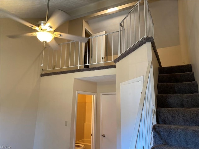 stairs featuring ceiling fan