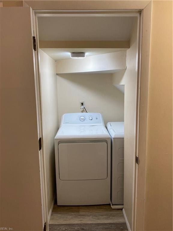 laundry area featuring separate washer and dryer and hardwood / wood-style flooring