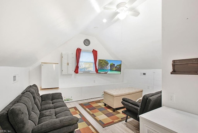 living room featuring ceiling fan, lofted ceiling, and light hardwood / wood-style flooring