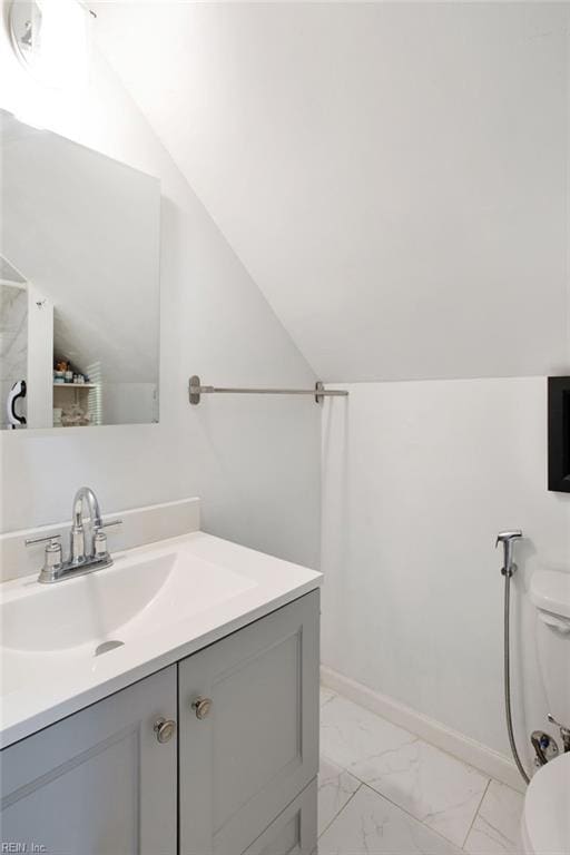 bathroom with vanity, toilet, and vaulted ceiling