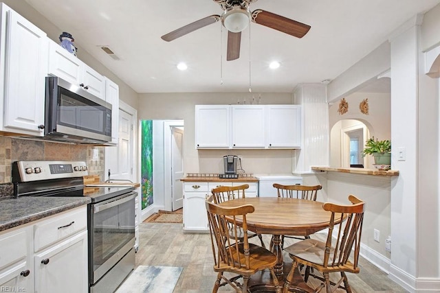 kitchen with white cabinetry, stainless steel appliances, and light hardwood / wood-style flooring