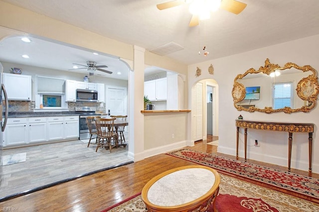 living room with ceiling fan and light hardwood / wood-style flooring