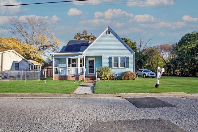 bungalow-style home featuring solar panels, a porch, and a front lawn