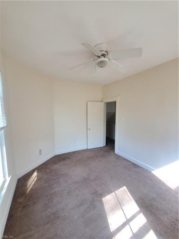 carpeted spare room featuring ceiling fan