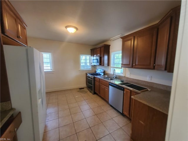 kitchen with sink, light tile patterned floors, and stainless steel appliances