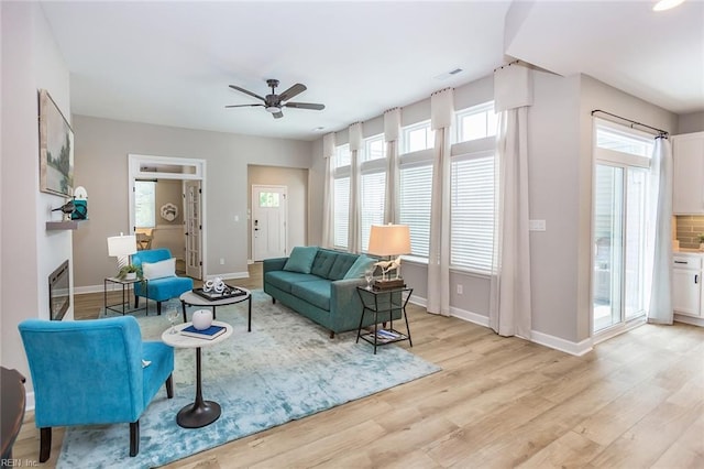 living room featuring ceiling fan and light hardwood / wood-style flooring