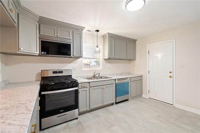 kitchen featuring pendant lighting, gray cabinets, sink, and appliances with stainless steel finishes