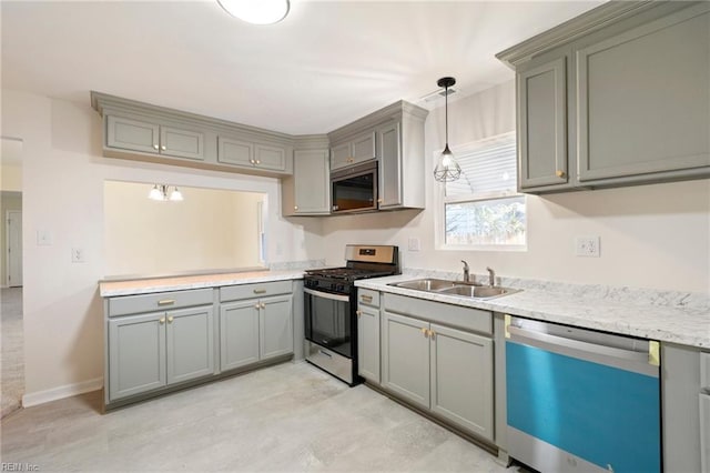 kitchen with appliances with stainless steel finishes, decorative light fixtures, gray cabinets, and sink